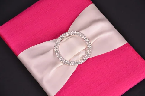 Fuchsia invitation fabric with a pale ribbon and circular crystal buckle