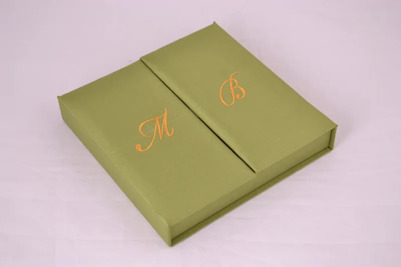 Green gatefold invitation box with gold-toned embroidered initials