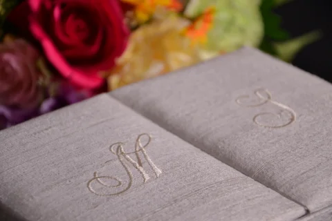 Taupe gatefold invitation box with embroidered initials on its two flaps