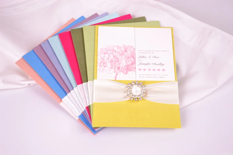 Colourful invitation presentations arranged in a fan with a yellow front piece