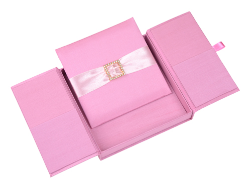 Pink gatefold silk invitation box opened to reveal a ribbon and square crystal embellishment