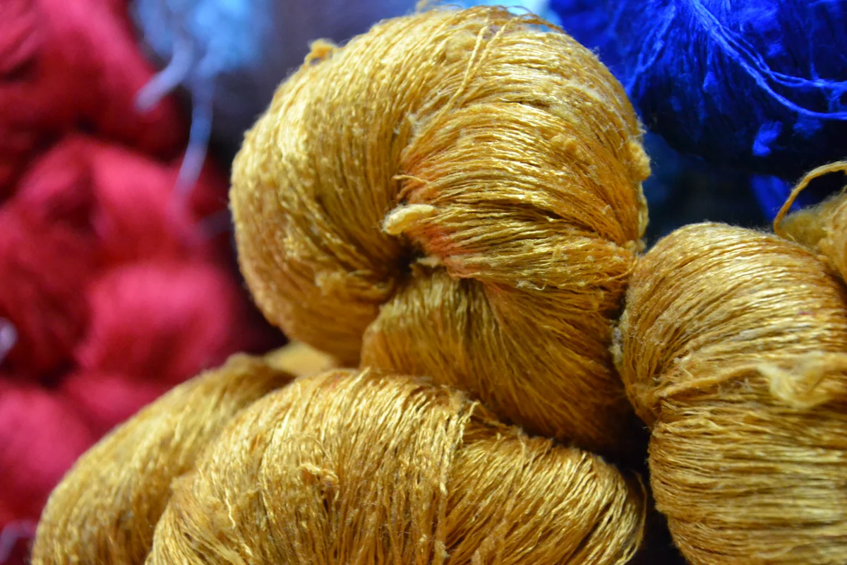 Silk yarn in golden yellow, pink and blue for handwoven Thai dupioni silk